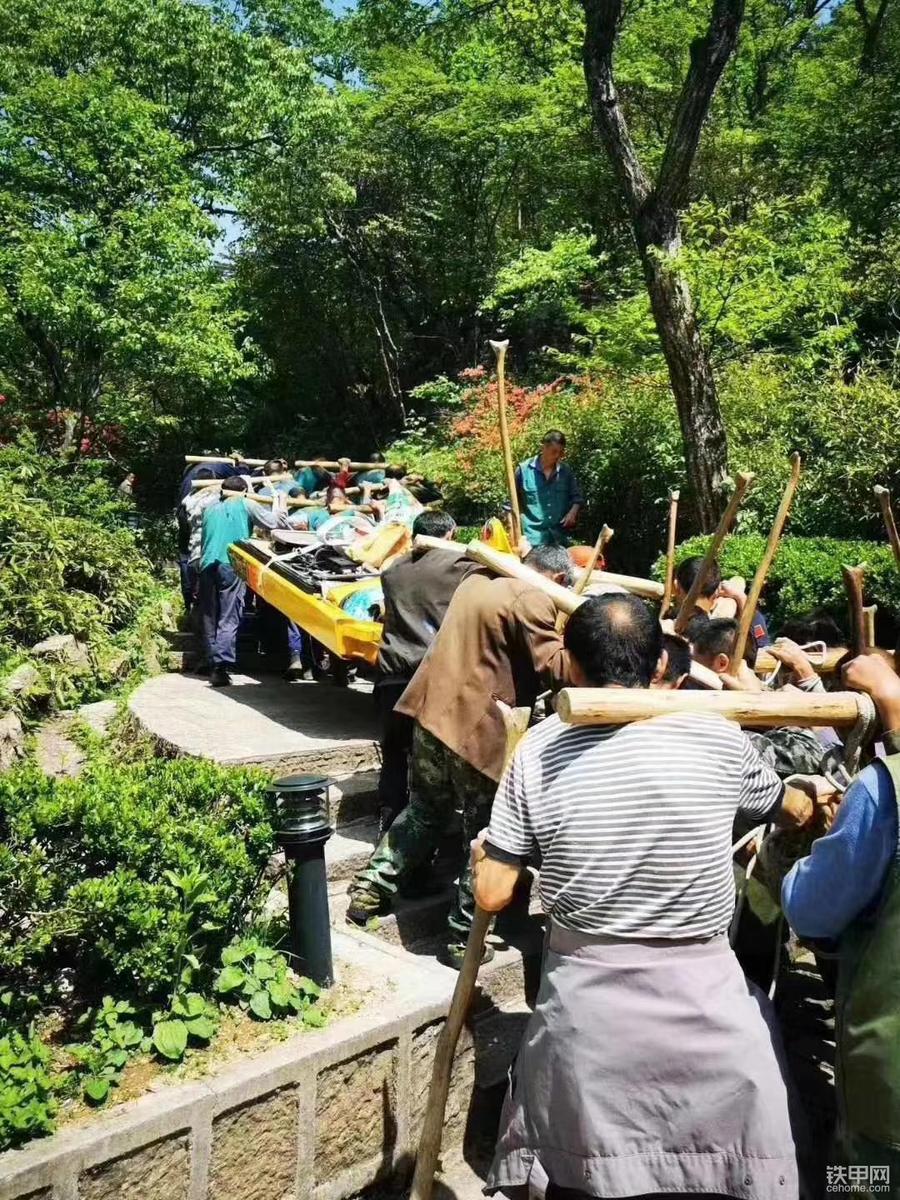 同舟共济,挖机部件被多人抬上山.
