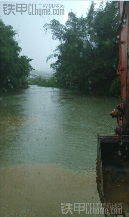 挖掘機(jī)雨中下河面作業(yè)