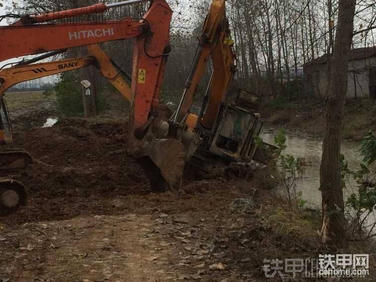 兩臺機(jī)子扒著鏈軌板，把它從水里扒正