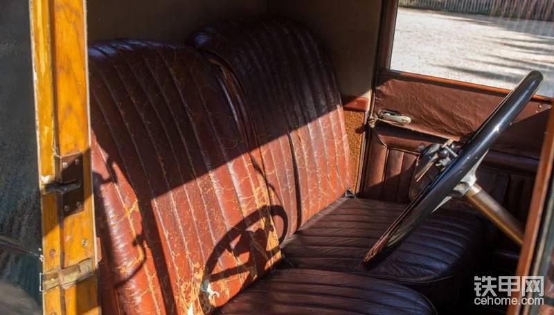 纯皮沙发座椅斑驳破旧，木质驾驶室在车门处纹路清晰