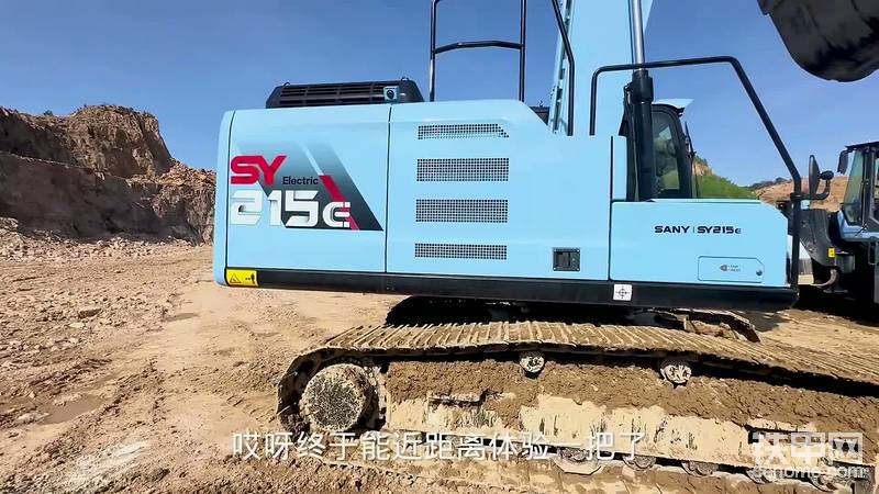 刚在现场坐下，各类电动设备便开始“表演”：大挖机、小挖机、电动铲车一一亮相，终于能近距离接触这些设备，现场的视觉冲击让他觉得很震撼。接着，他迎来了期待已久的体验——开215型号的电动挖机。这台挖机是天蓝色涂装，外观漂亮，尾部还装了后置摄像头，设计贴心。